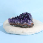 Amethyst crystal on a white stone with a light blue background