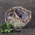 Geode with internal crystal structure on a stand against a dark background