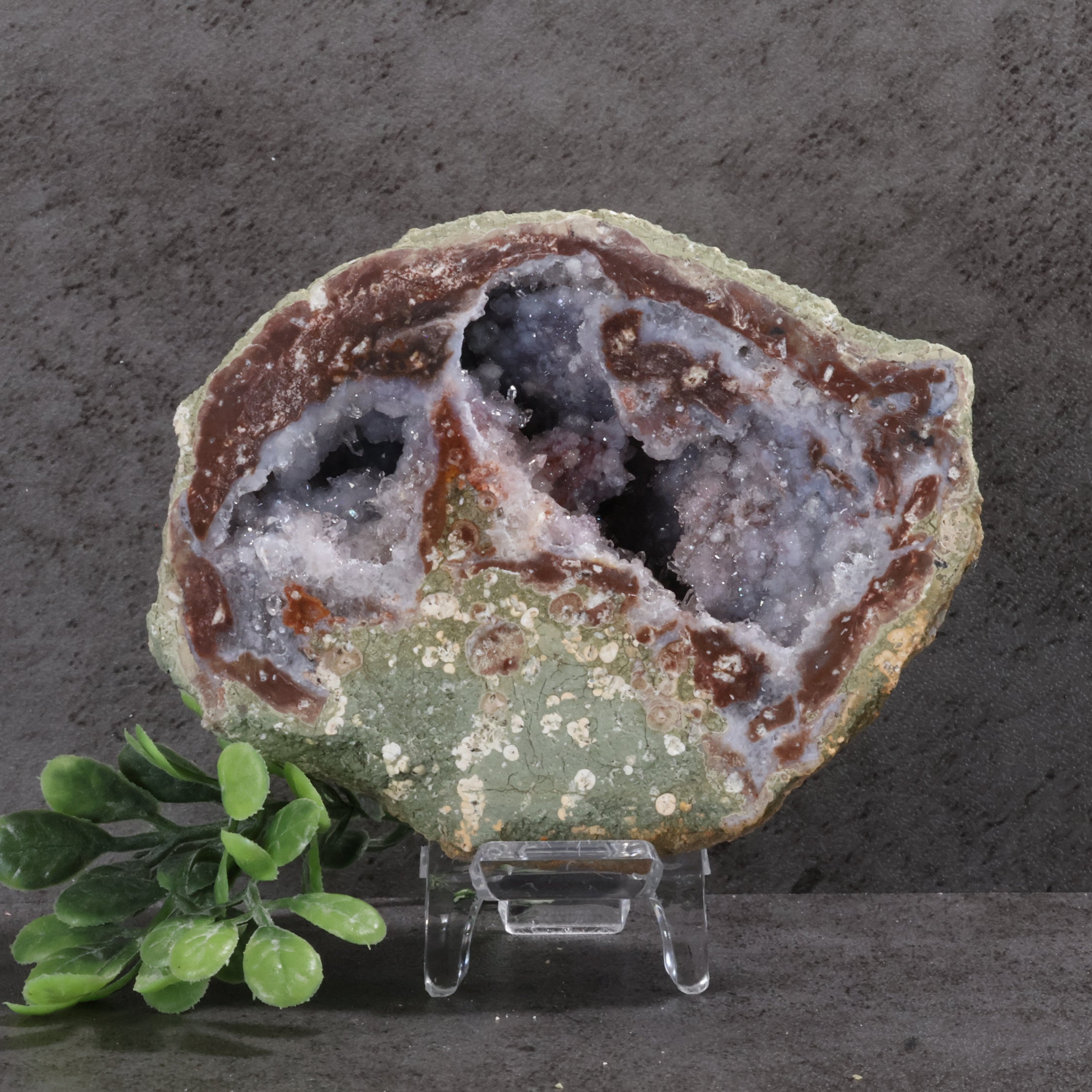 Geode with internal crystal structure on a stand against a dark background