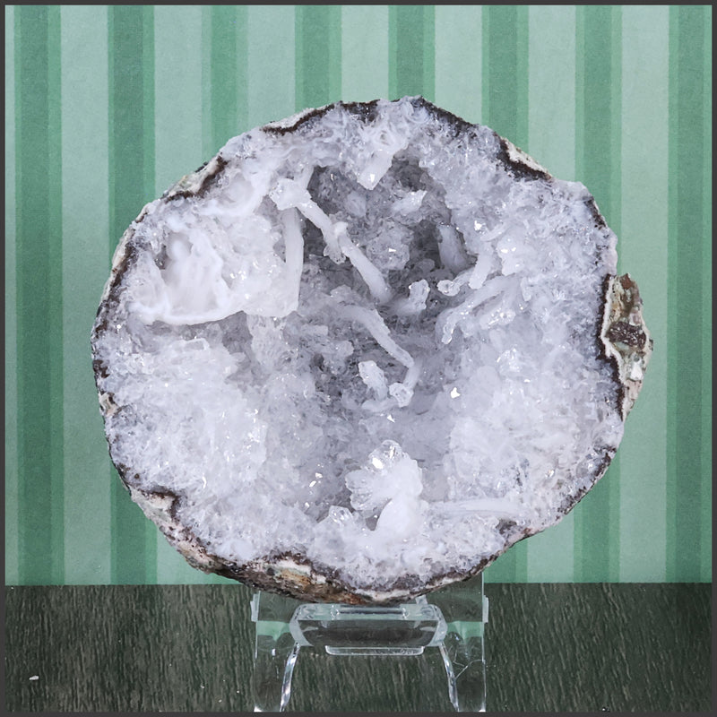Geode crystal on a stand with a striped green background